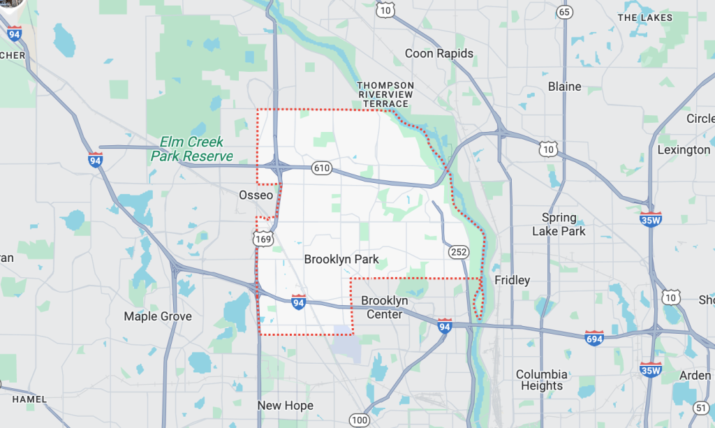 Tow truck assisting a broken-down car on the roadside in Brooklyn Park, MN.