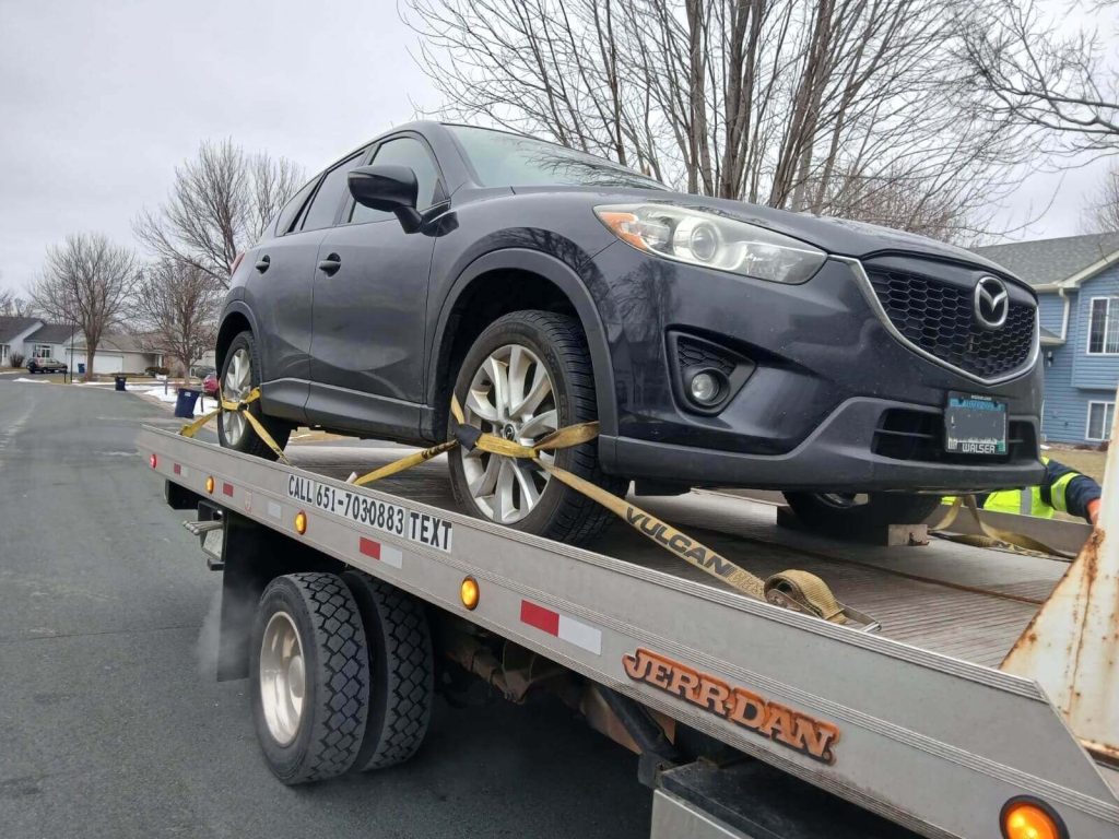 Flatbed tow truck safely transporting a vehicle in Eagan.