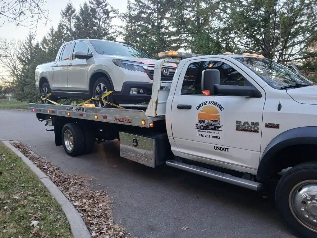 Professional tow truck near me safely towing a car